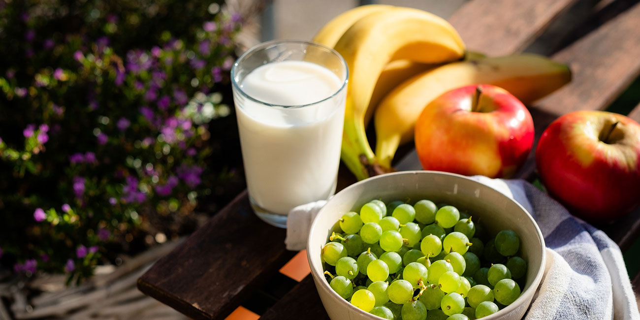 Milchlas, Trauben, Bananen und ein Apfel